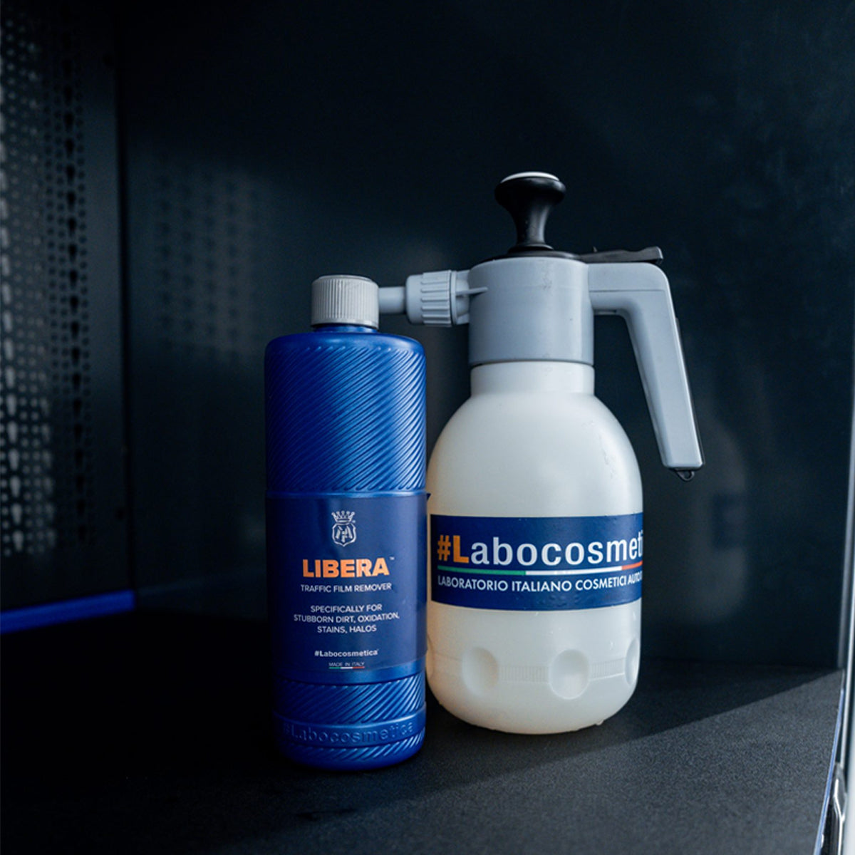 Blue bottle and white spray bottle with visible branding on a dark background