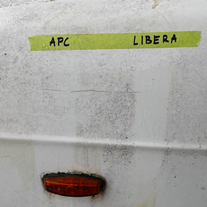 White surface with green tape labeled 'APC' and 'LIBERA', and a red light below.