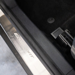 Close-up of a car door with a visible brand logo on the door frame.