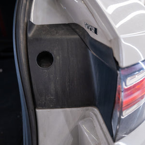 Close-up of a car's rear bumper with a visible brand logo.