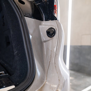 Close-up of a car door with water droplets on a white background