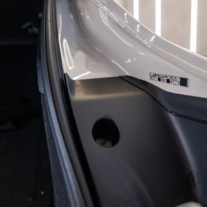 Close-up of a car door with a visible license plate number and vehicle identification label.