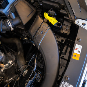 Close-up of a car's engine compartment with various components.