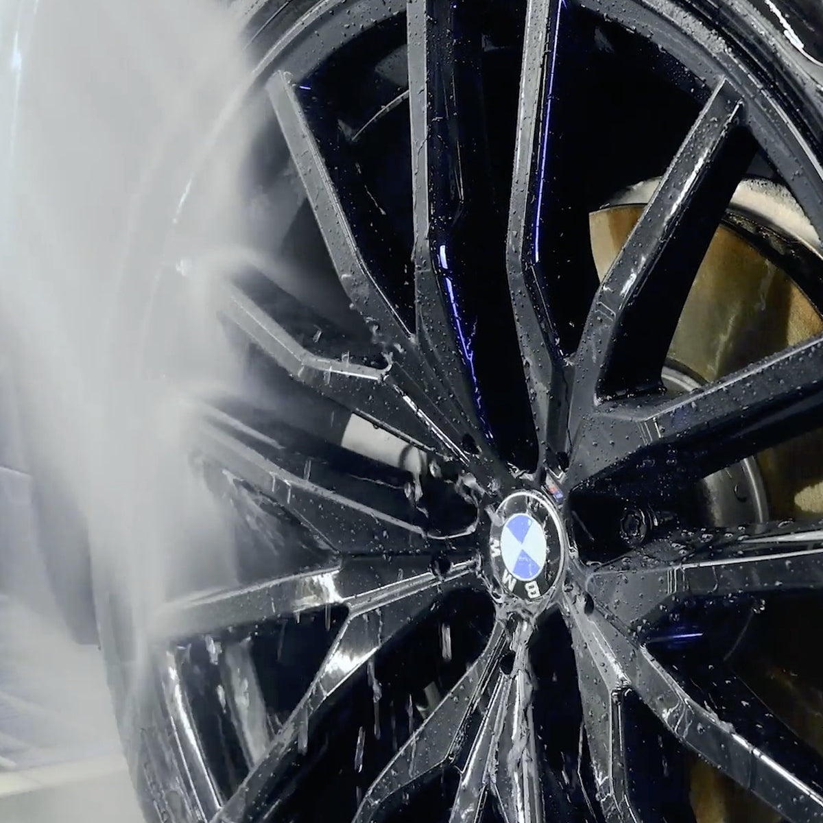 Close-up of a black alloy wheel with a visible BMW logo.