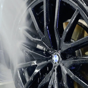Close-up of a black alloy wheel with a visible BMW logo.