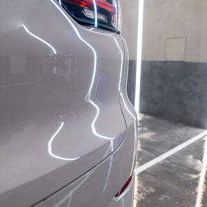 Close-up of a white car's side panel with a blurred background