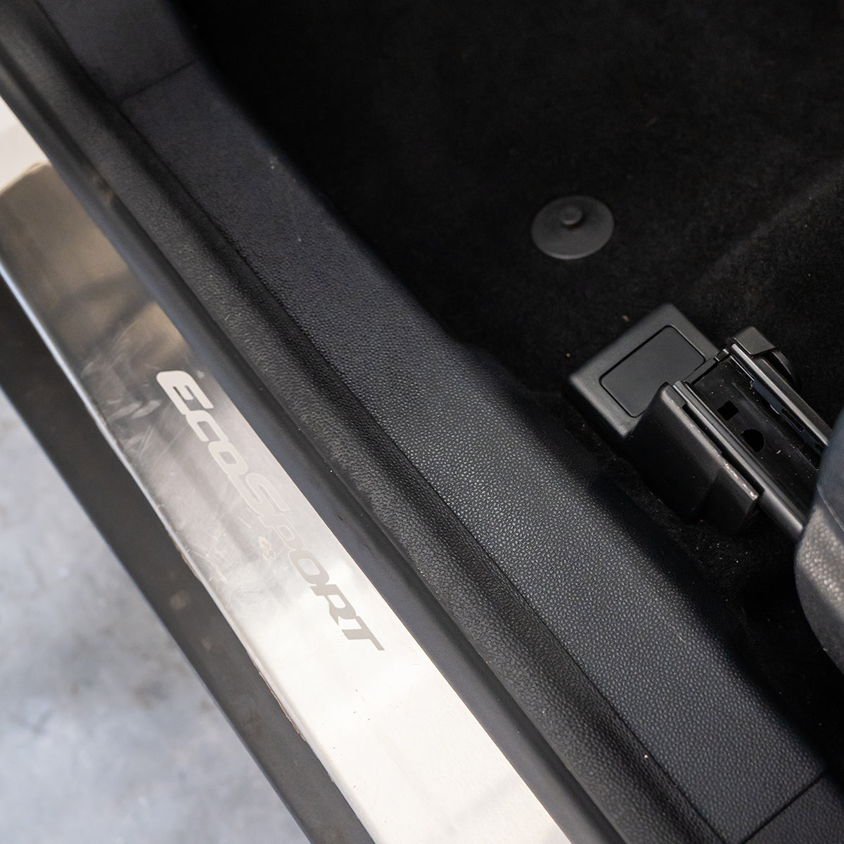 Close-up of a car door with a visible brand logo on the door frame.