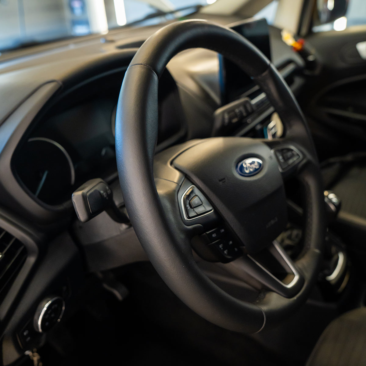 Steering wheel with Ford logo in a car interior