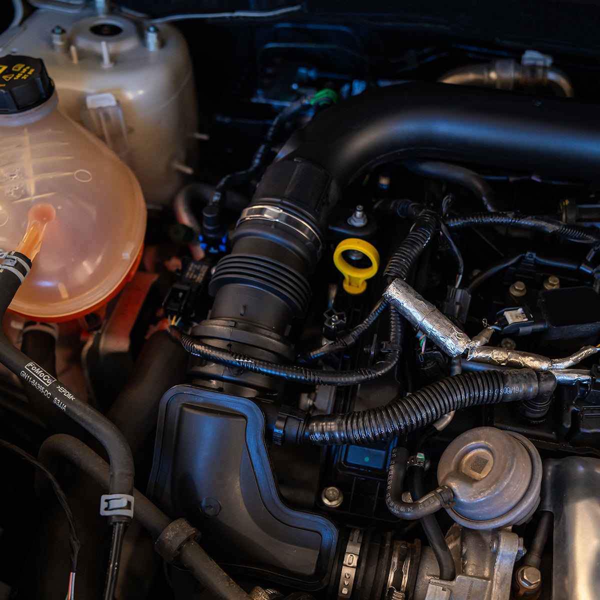 Close-up of a car engine with various components.